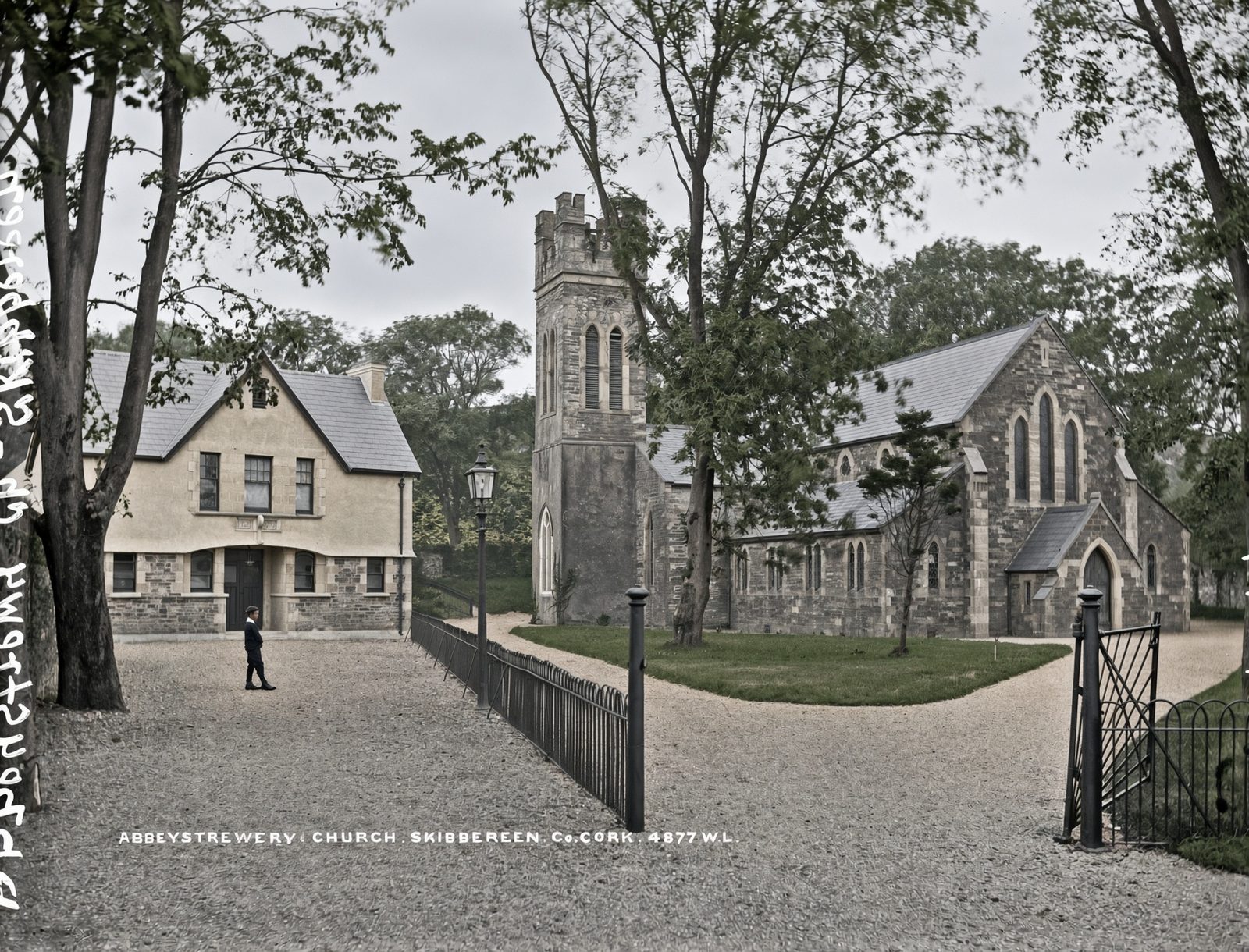 Abbeystrewery church and graveyard outside Skibbereen, behind iron gates and trees.