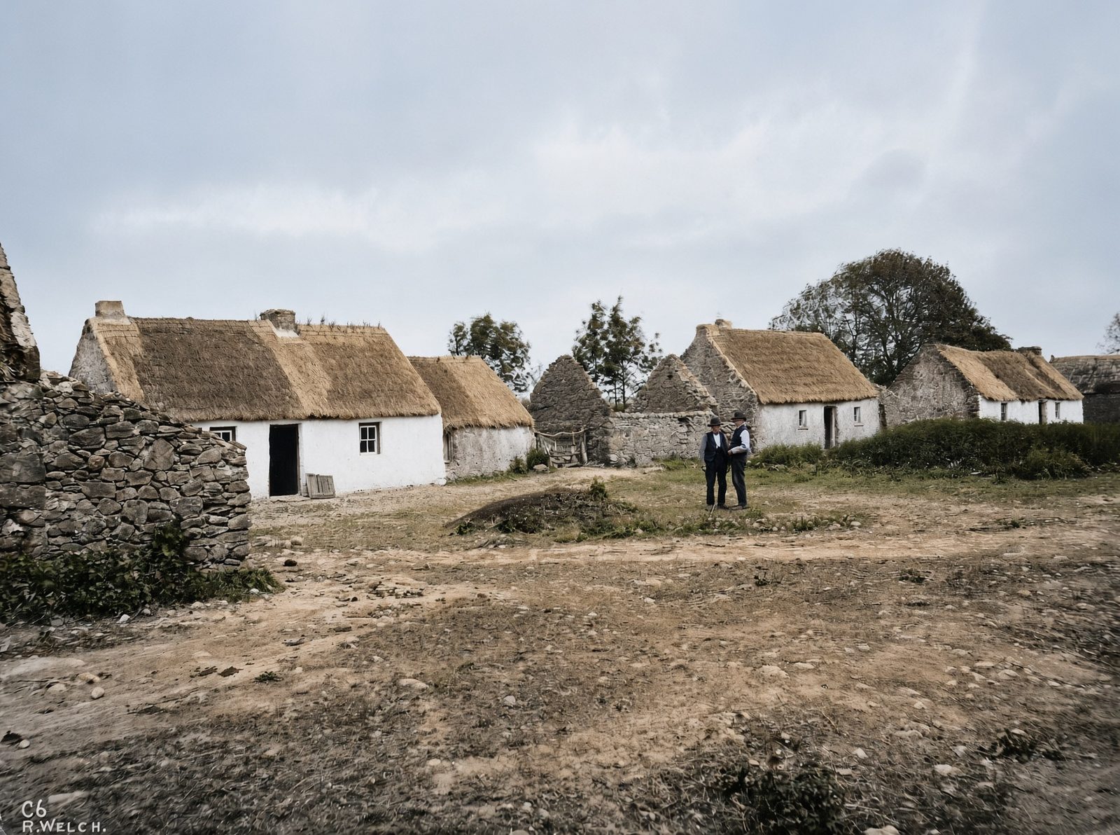 Thatched cottages crowded together on bare ground at Graigue, County Galway.
